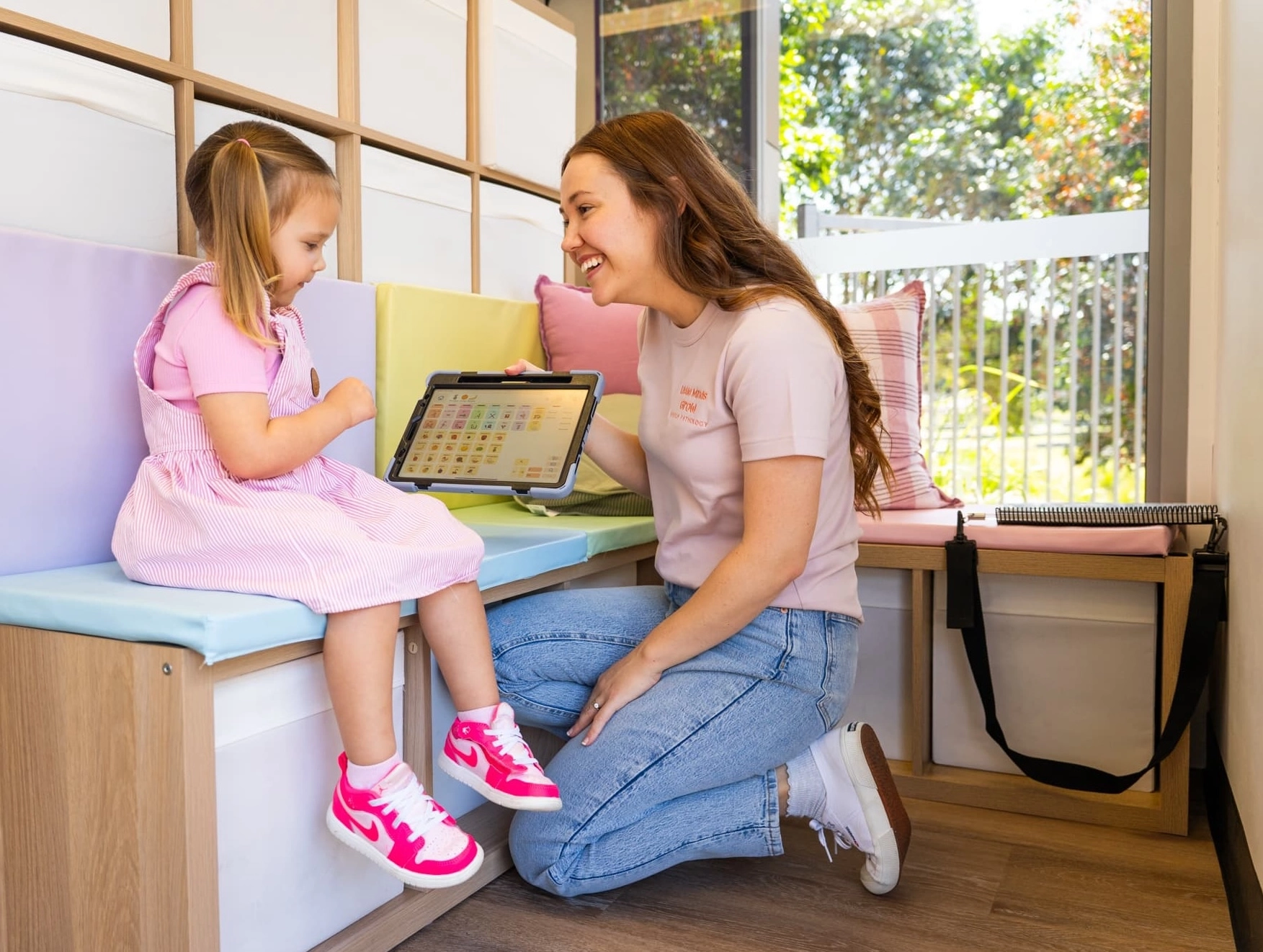 Speech pathologist in an AAC therapy session with her client