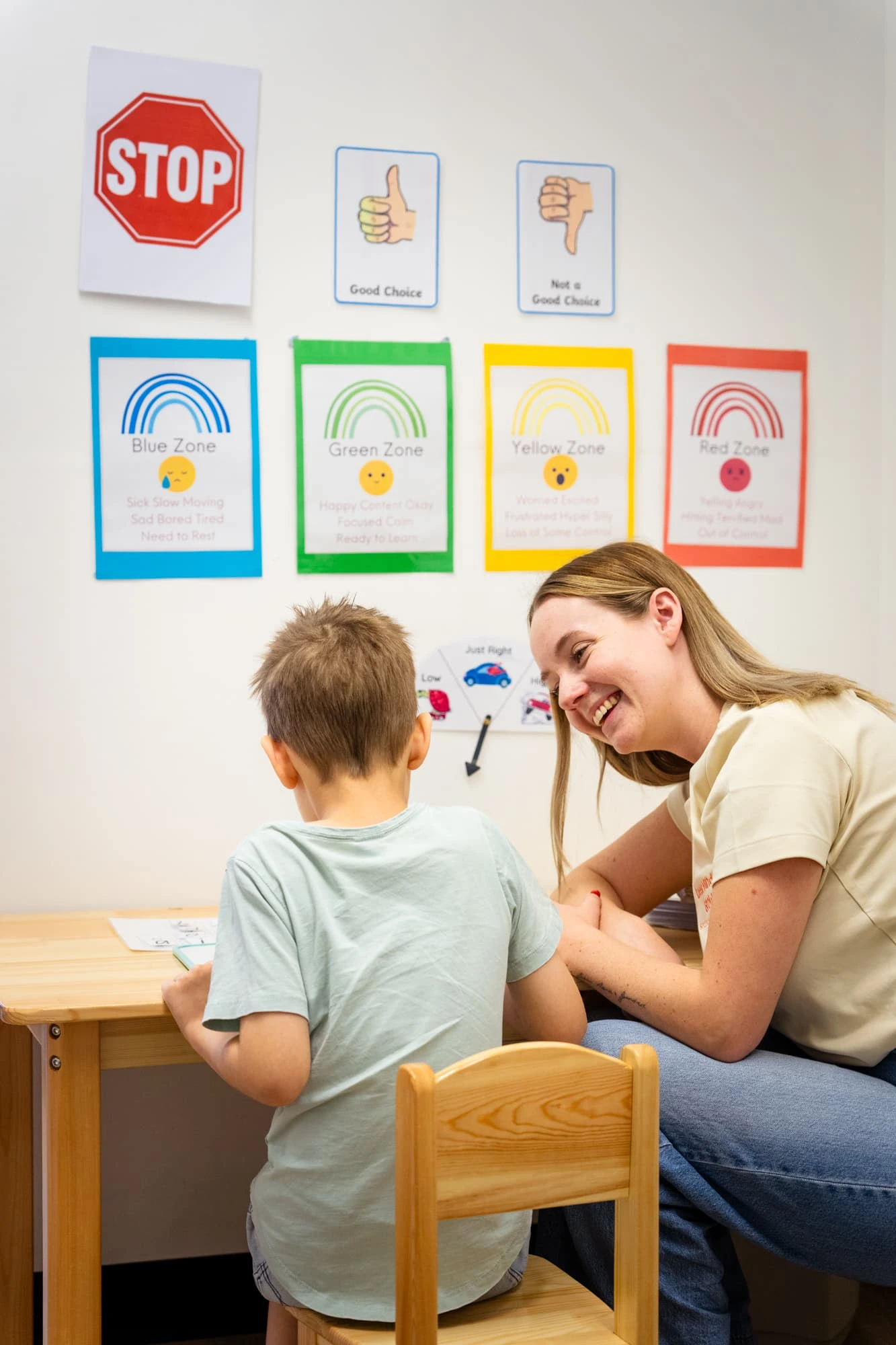Speech pathologist supporting a child during a paediatric speech therapy session