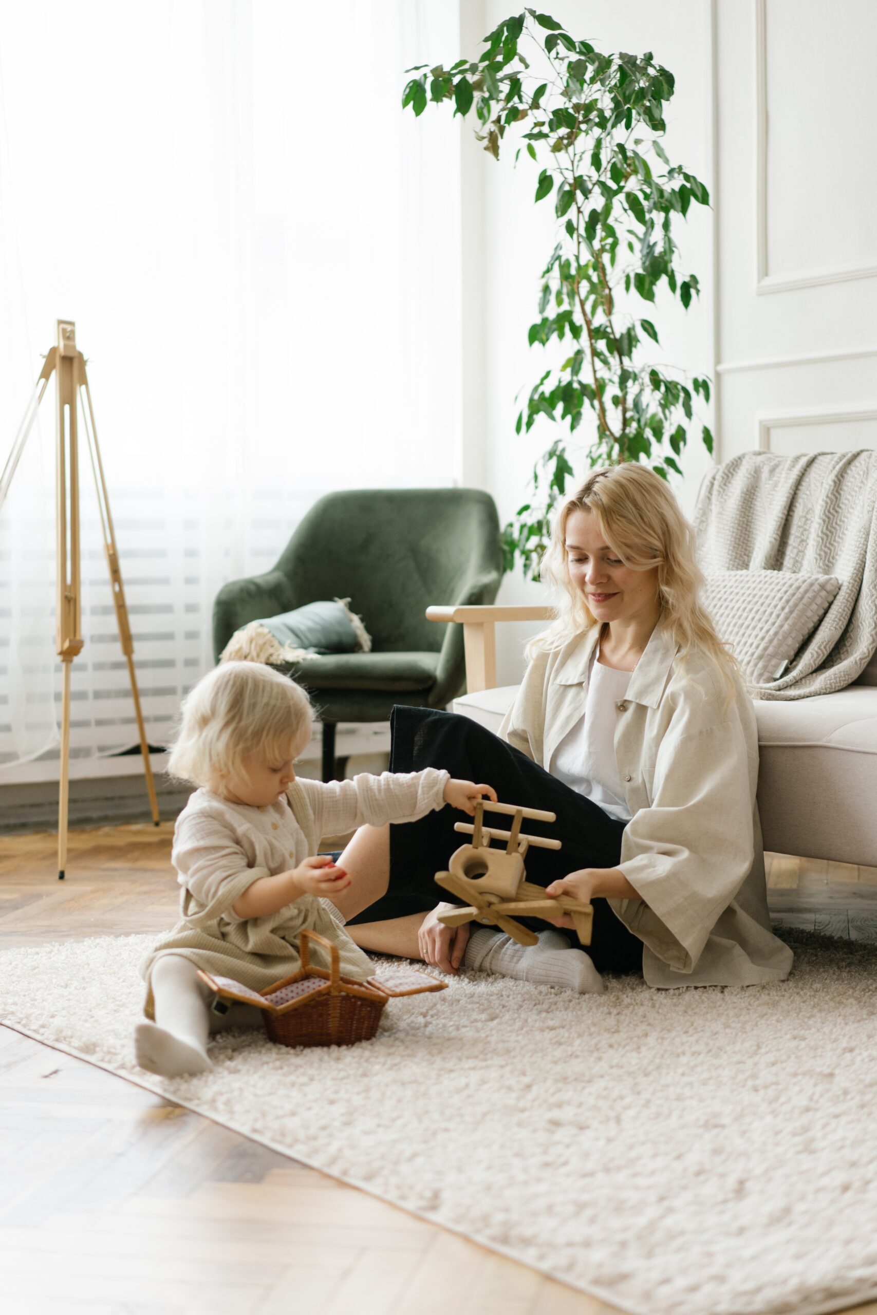 A toddler playing with a woman as part of a speech therapy for kids session.